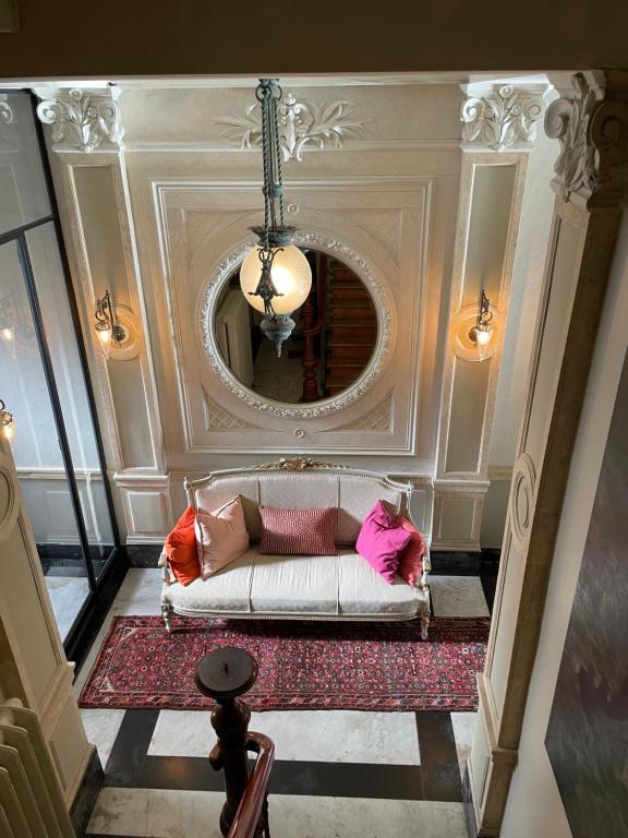 a living room with a white couch and a mirror at Huis Dujardin Bed&Breakfast in Antwerp