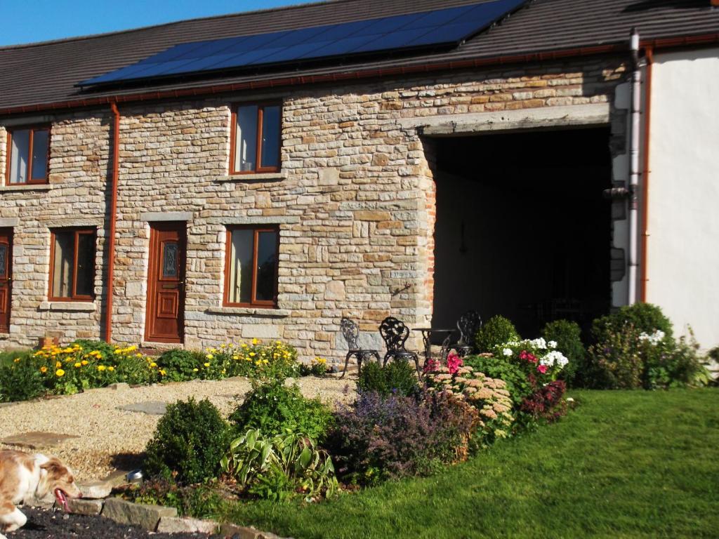 una casa de piedra con un banco delante en Peers Clough Farm Cottage, en Rossendale