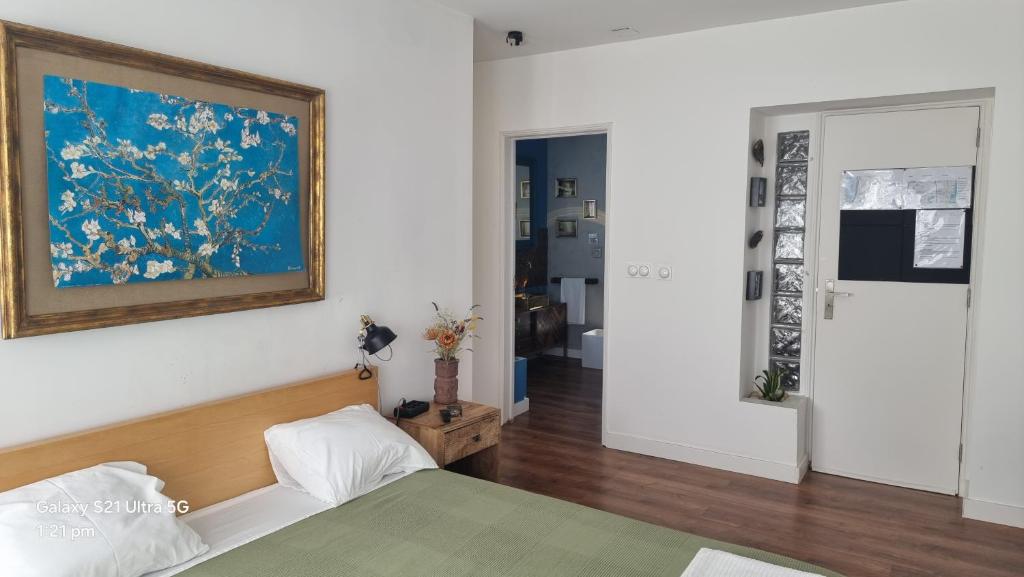 a bedroom with a bed and a painting on the wall at The Coolest Place near the airport! in Lisbon