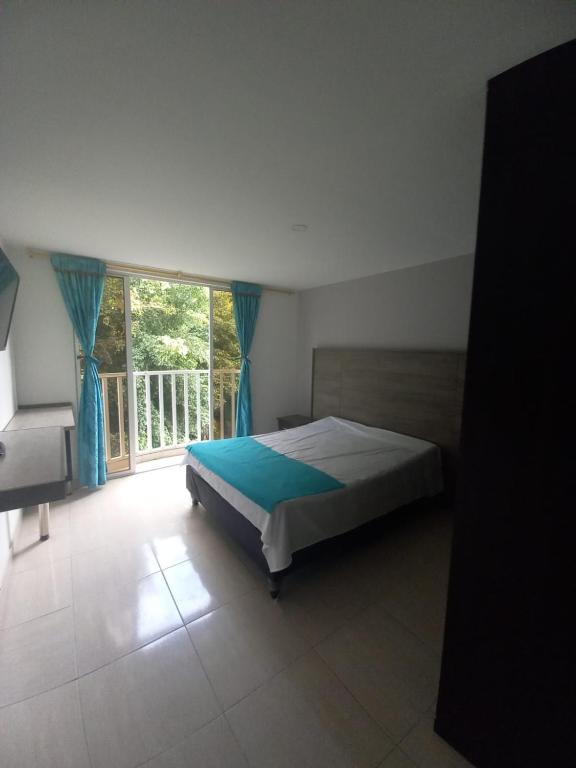 a bedroom with a bed and a large window at Apartaestudios amoblados el caney in Cali
