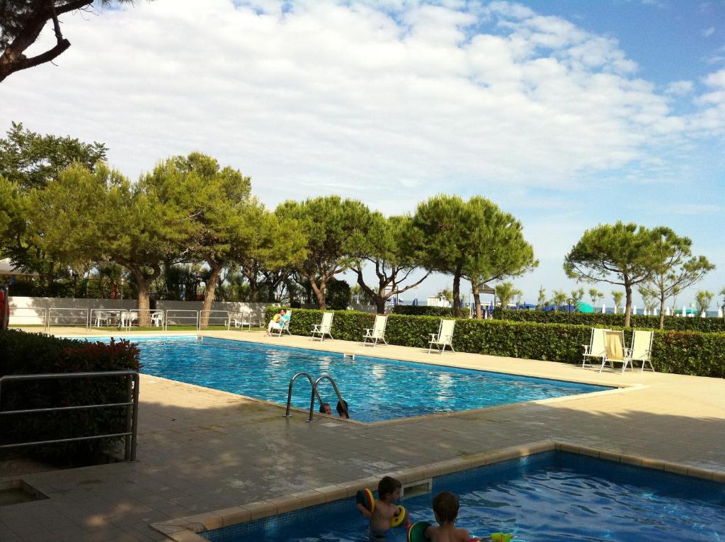 uma piscina com duas crianças a brincar na água em RESIDENCE GARDEN -WALTERIGATO Apartments SOLO PER FAMIGLIE em Lido di Jesolo