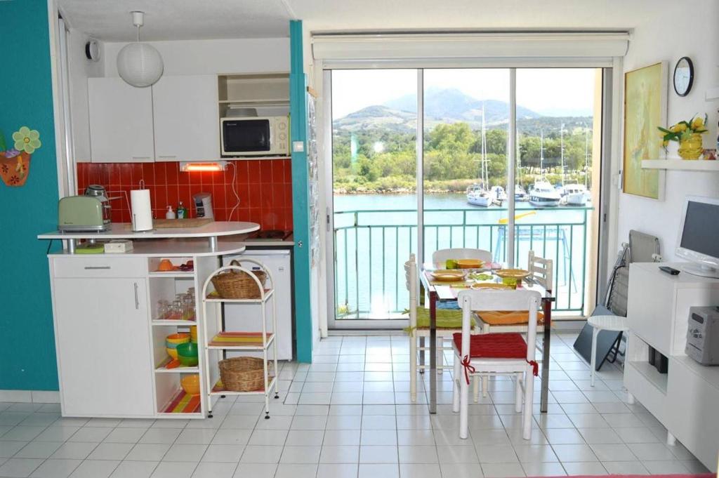 - une cuisine avec une table et une vue sur l'eau dans l'établissement Appartement deux pièces cabine ARGELES SUR MER AR260-214, à Argelès-sur-Mer