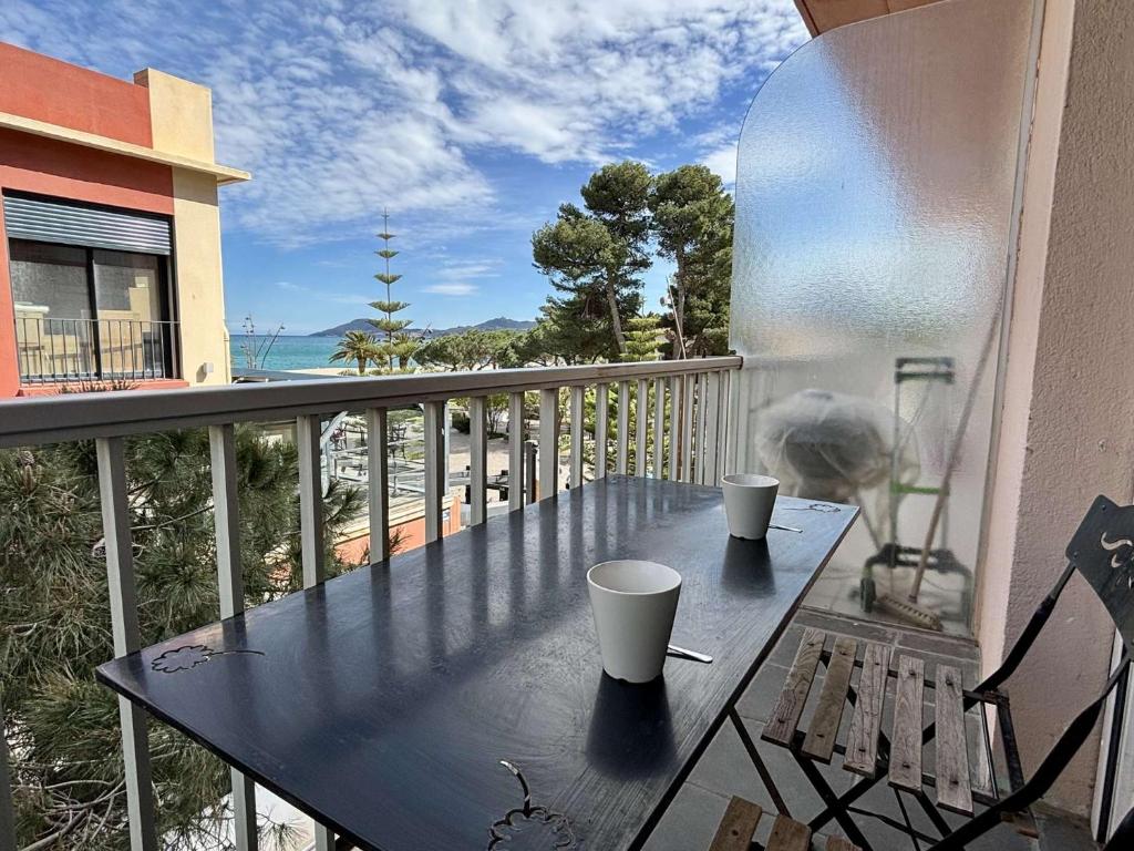 - une table sur un balcon avec vue sur l'océan dans l'établissement Appartement 2 pièces 4 couchages ARGELES SUR MER AR910-016, à Argelès-sur-Mer
