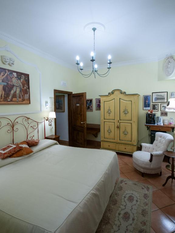 a bedroom with a large bed and a chandelier at Mondo Antico R&B in Cesena