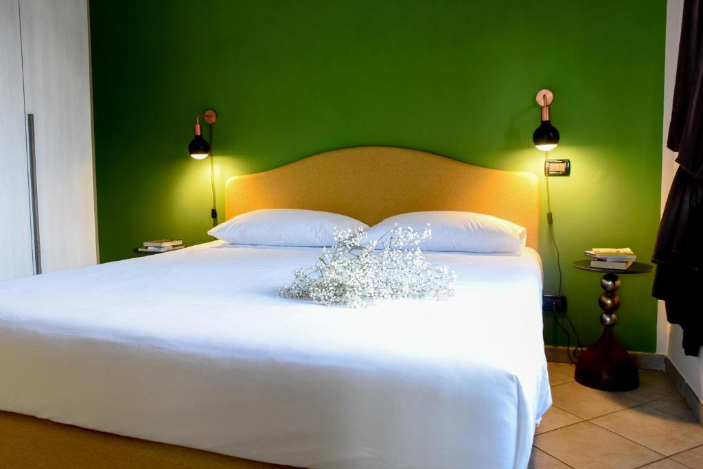 a bedroom with a white bed with a green wall at Casa Artemisia in Canale