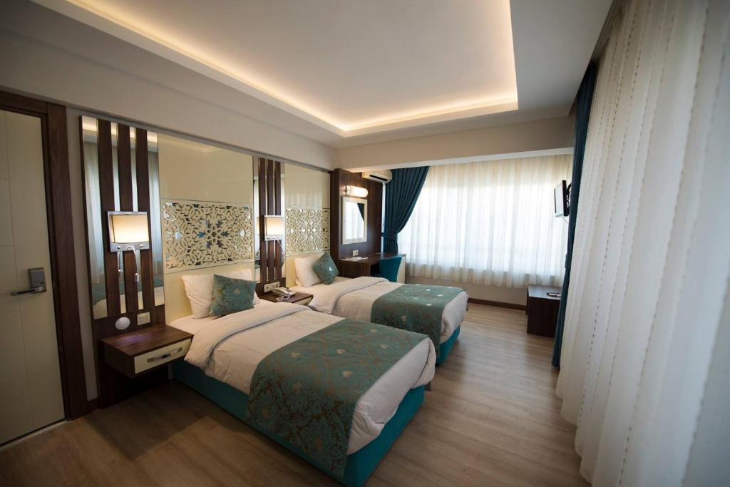 Un pat sau paturi într-o cameră la Rest Inn Aydın Hotel