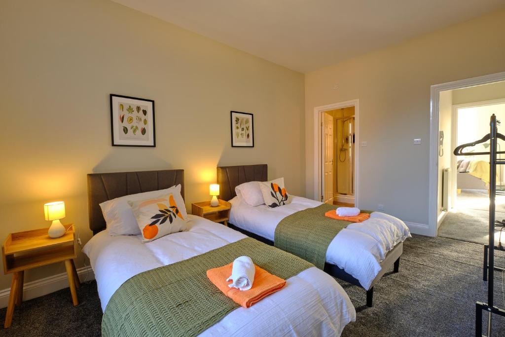 a bedroom with two beds with towels on them at Large 2-3 Bed FREE Parking, En-suite in Harrogate