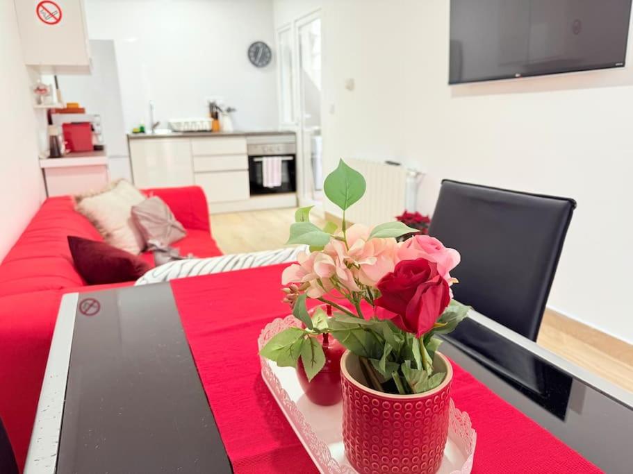 a table with a vase of roses on top of it at Rosa House, Chalet 4 habitaciones y 4 baños in Pozuelo de Alarcón