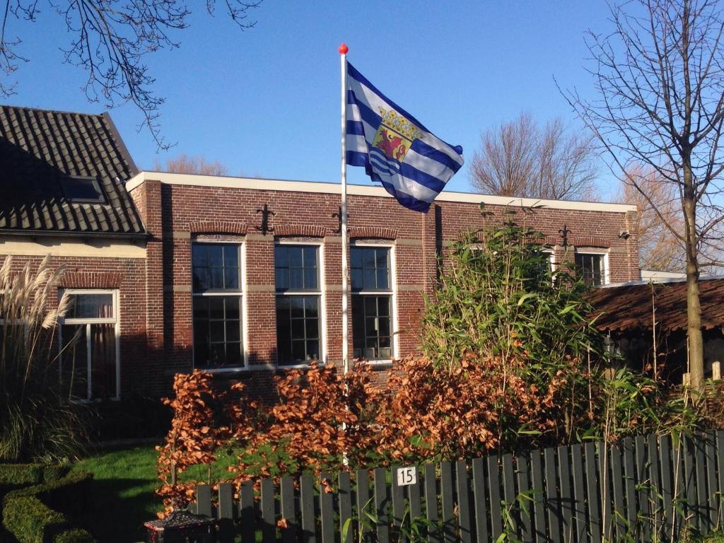 een vlag voor een bakstenen gebouw bij Suite School 15 A in Zonnemaire