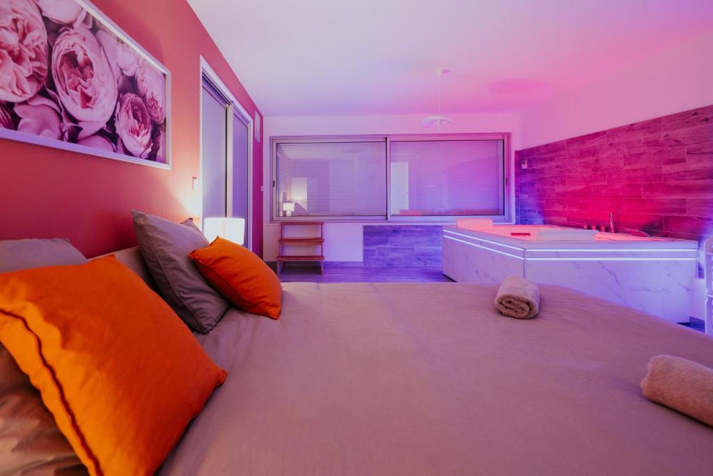 a bedroom with a large bed and a bath tub at AppartSpa59 - Suite Tentation - Balnéo, Sauna - Secret Room en option supplémentaire in Valenciennes
