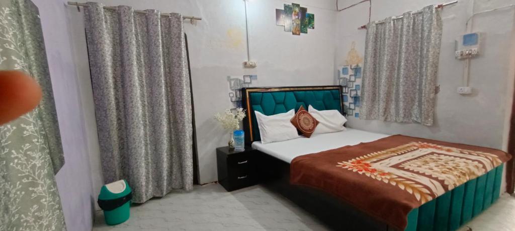 1 dormitorio pequeño con cama y cortinas en Shriji Home stay, en Mathura