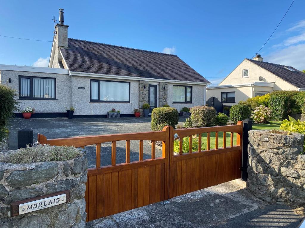a wooden fence in front of a house at 2 Bed in Moelfre 75013 in Moelfre