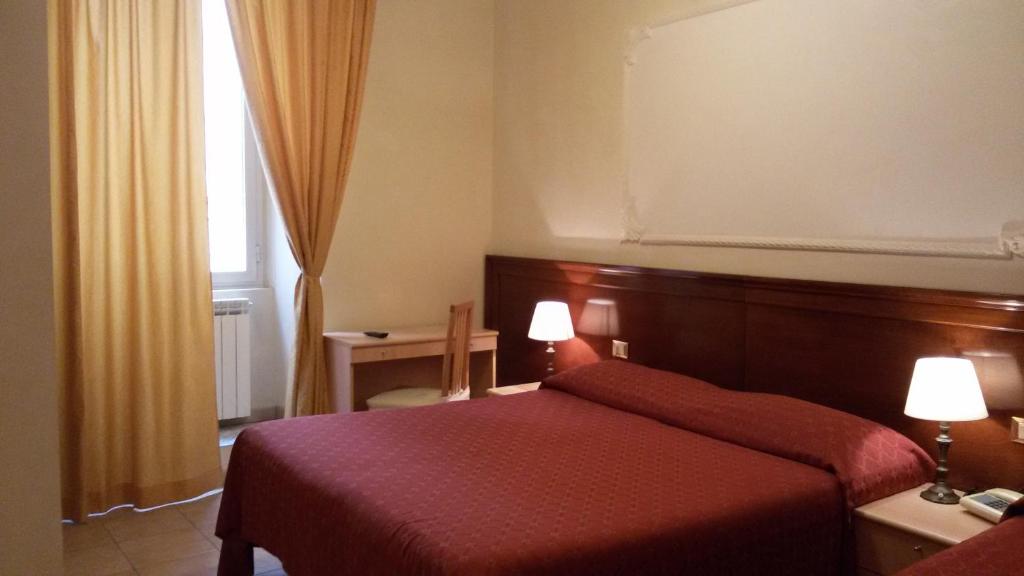 ローマにあるHotel Rosettaの赤いベッドと窓が備わるホテルルームです。