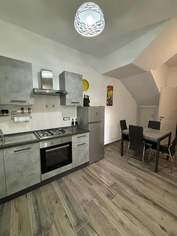 a kitchen with a stove and a table with chairs at Solemar2 in Giardina Gallotti
