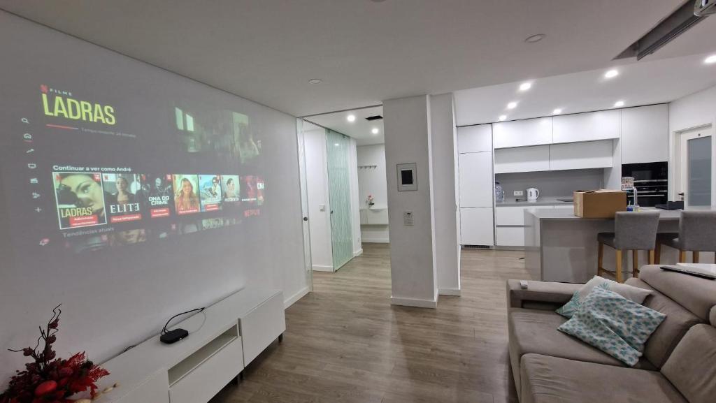 a living room with a couch and a kitchen at Feira Central Loft in Santa Maria da Feira