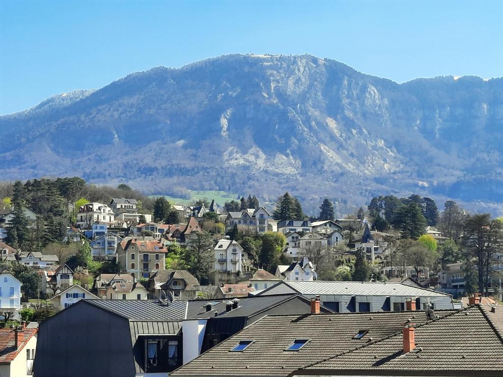 Une ville avec des maisons et une montagne en arrière-plan dans l'établissement Plein Soleil, à Aix-les-Bains