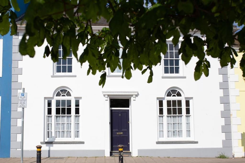 a white house with a black door and windows at Harbourside luxury house in Aberaeron