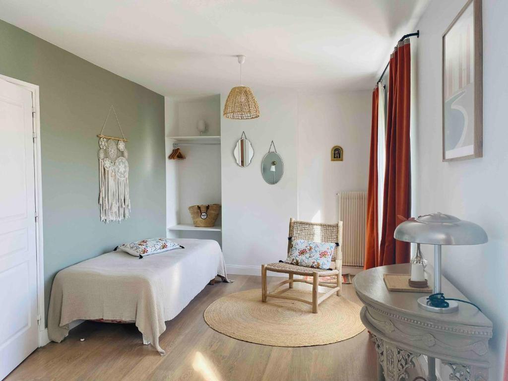 a bedroom with a bed and a chair and a table at Le Moulin Du Port in Saint-Georges-sur-Cher