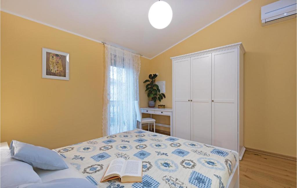 sypialnia z łóżkiem i książką na nim w obiekcie Two-Bedroom Holiday Home In Barbariga w mieście Barbariga