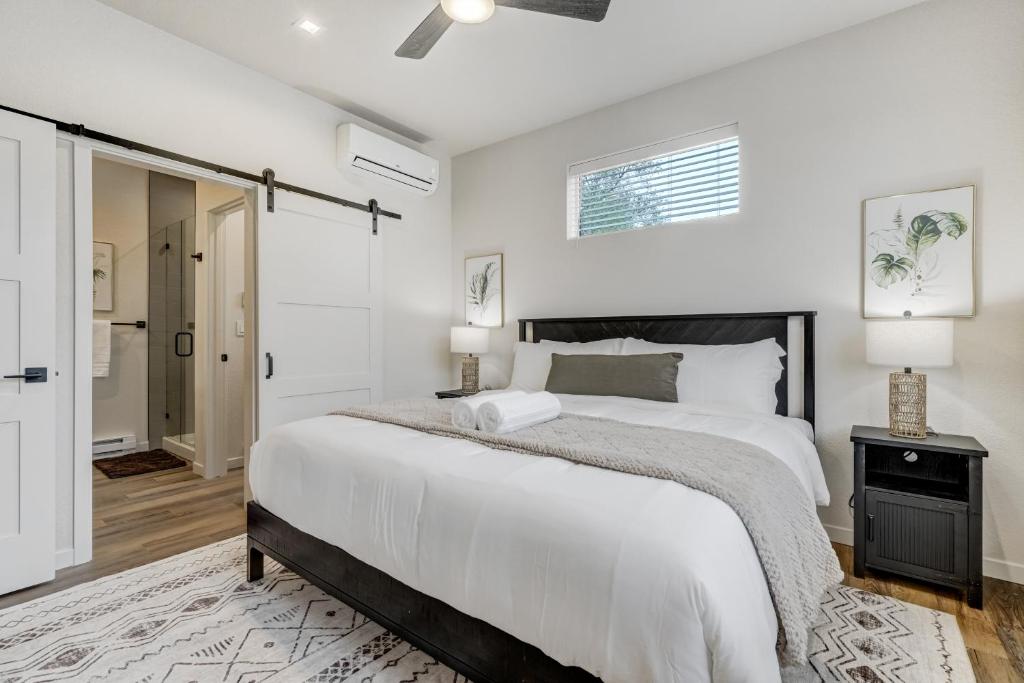 ein weißes Schlafzimmer mit einem großen Bett und einem Nachttisch in der Unterkunft El Paso Executive Suites - Pet Friendly NEW BUILD in Colorado Springs