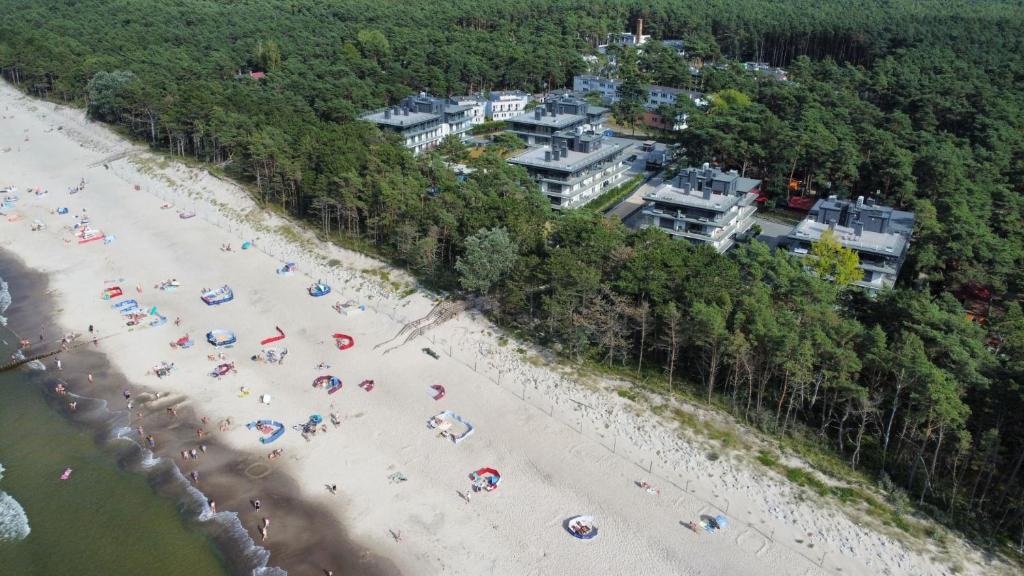 una vista dall'alto di una spiaggia con persone e ombrelloni di Apartament Baltic Zefir Pogorzelica Sea&Spa-Hevenia a Pogorzelica