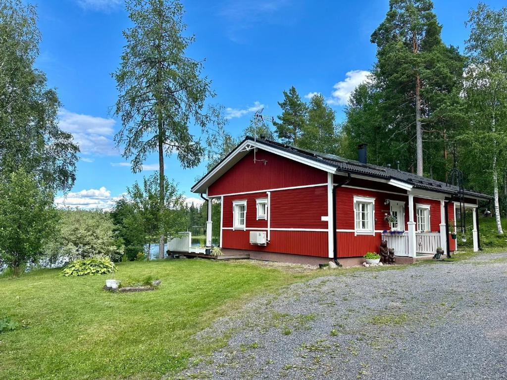 una casa roja en medio de un campo en Villa Kesälä, en Ylöjärvi