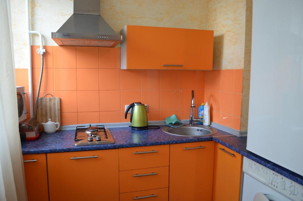 キーウにあるApartment Laboratorniy per. 26のキッチン(オレンジ色のキャビネット、シンク付)