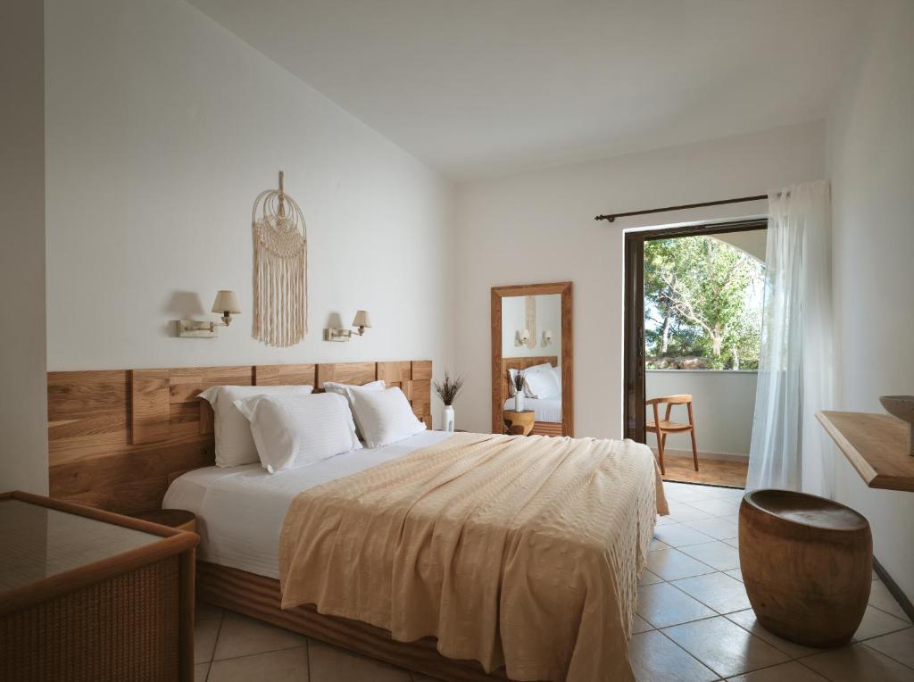 ein Schlafzimmer mit großem Bett und Fenster in der Unterkunft AQUARIUS HOTEL in Vasilikos