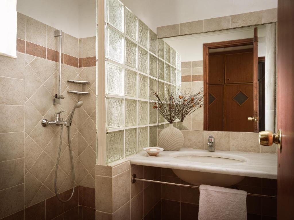 ein Badezimmer mit Waschbecken und Dusche in der Unterkunft AQUARIUS HOTEL in Vasilikos