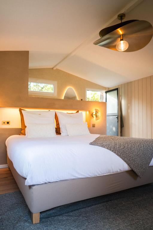 une chambre avec un grand lit blanc avec un plafond dans l'établissement La Métairie De Terrefort, à Bouliac