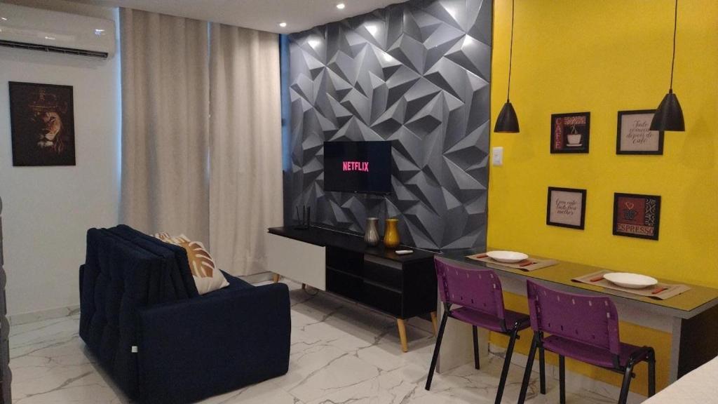 a living room with a table and purple chairs at Studio Pelourinho, Salvador in Salvador