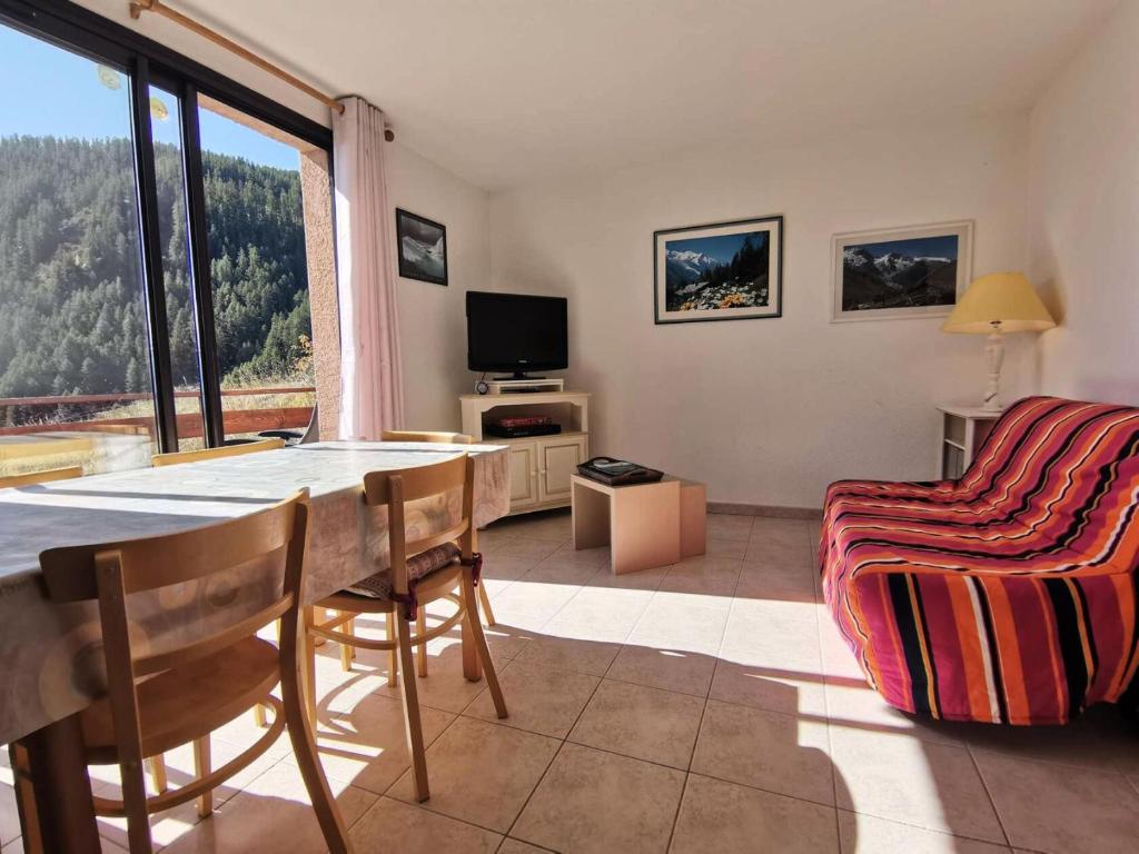 a living room with a table and chairs and a television at Résidence Oucanes - Superbe T3 avec accès direct aux pistes de Réallon OUC7 MAE-8401 in Réallon