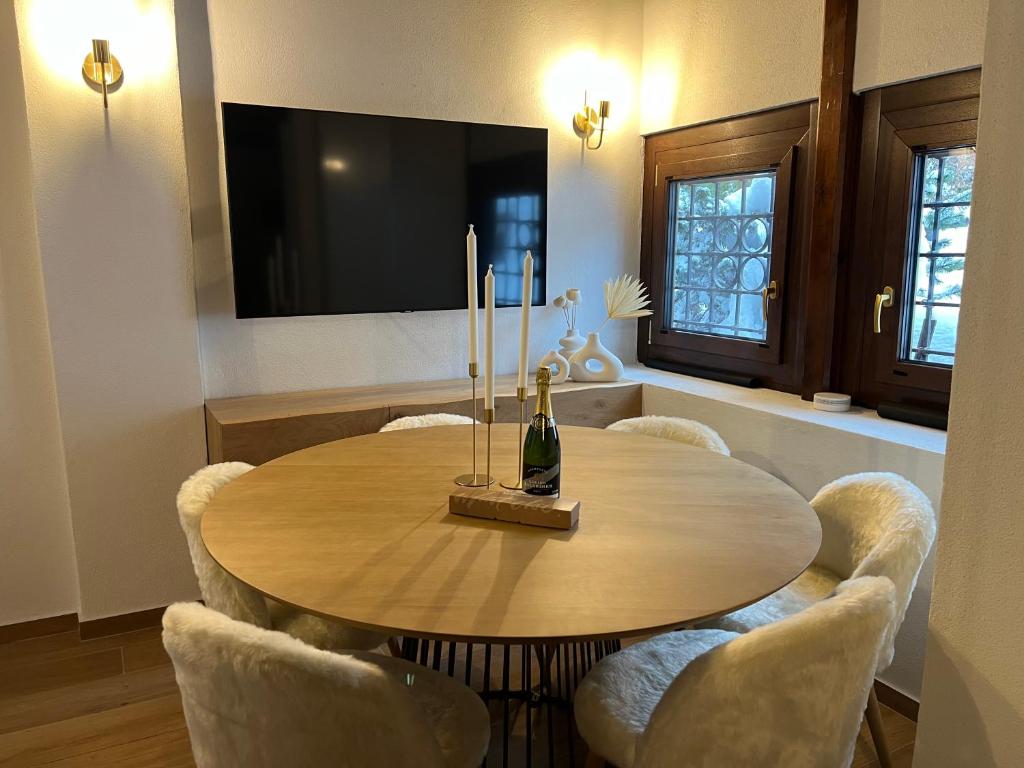 a dining room with a table with chairs and a bottle of wine at Chalet in Courmayeur near Lifts & Centre 2BR 2BA in Courmayeur