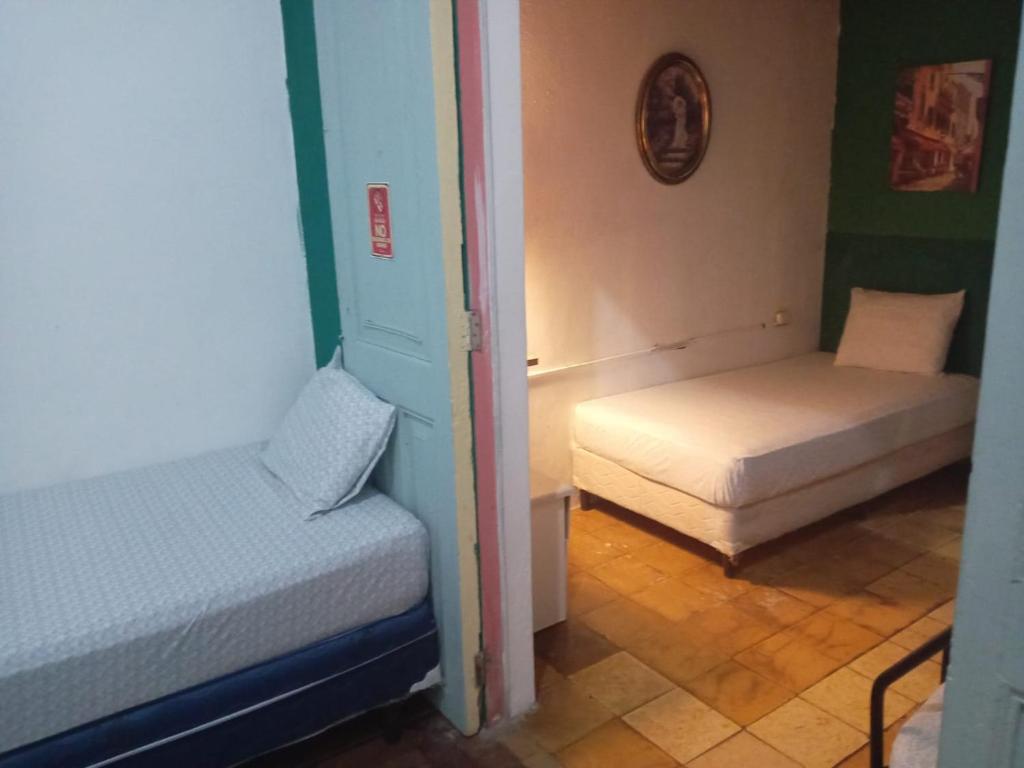 una stanza con due letti in una stanza di Hostal Brunette Santein a Santa Ana