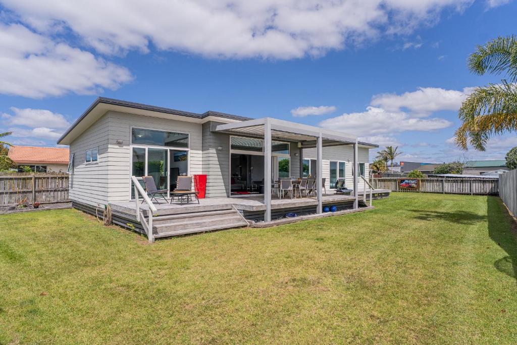 a small house with a porch and a yard at Hosts on the Coast Belair Bach in Whitianga