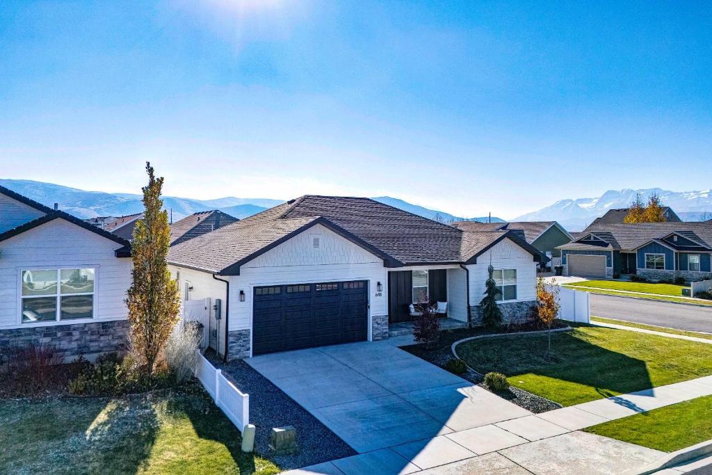 a house with a garage with mountains in the background at Hot Tub, Heber Home, Pet-Friendly, Games, Sleeps 13 Guest! in Heber City
