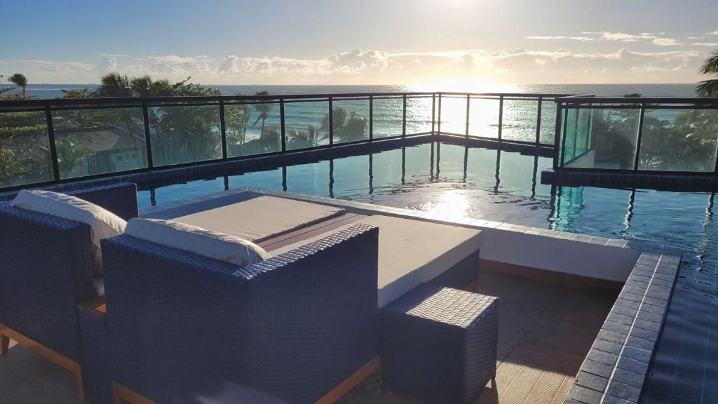 a swimming pool with a view of the ocean at Apê aconchegante a 50m do mar - Maracaípe in Porto De Galinhas