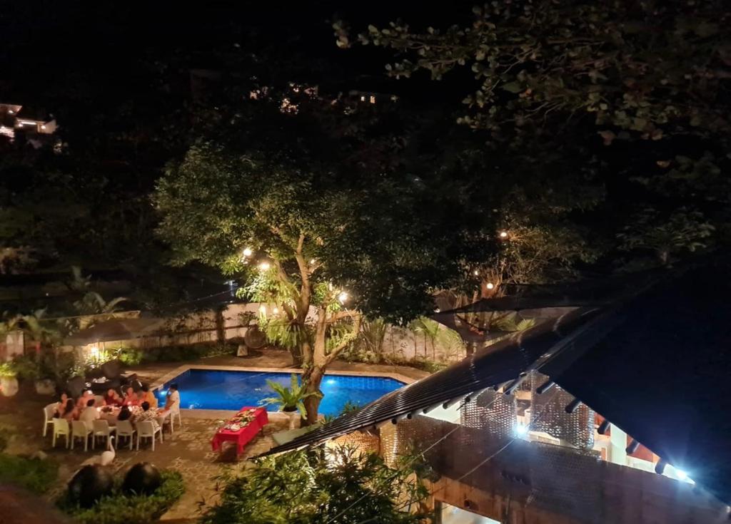 a group of people sitting around a pool at night at Amor 2 Bedroom with Jacuzzi in Boracay