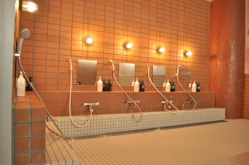 木曽町にあるロッジ三笠 Lodge Mikasaの赤いタイル張りのバスルーム(シャワー、鏡付)