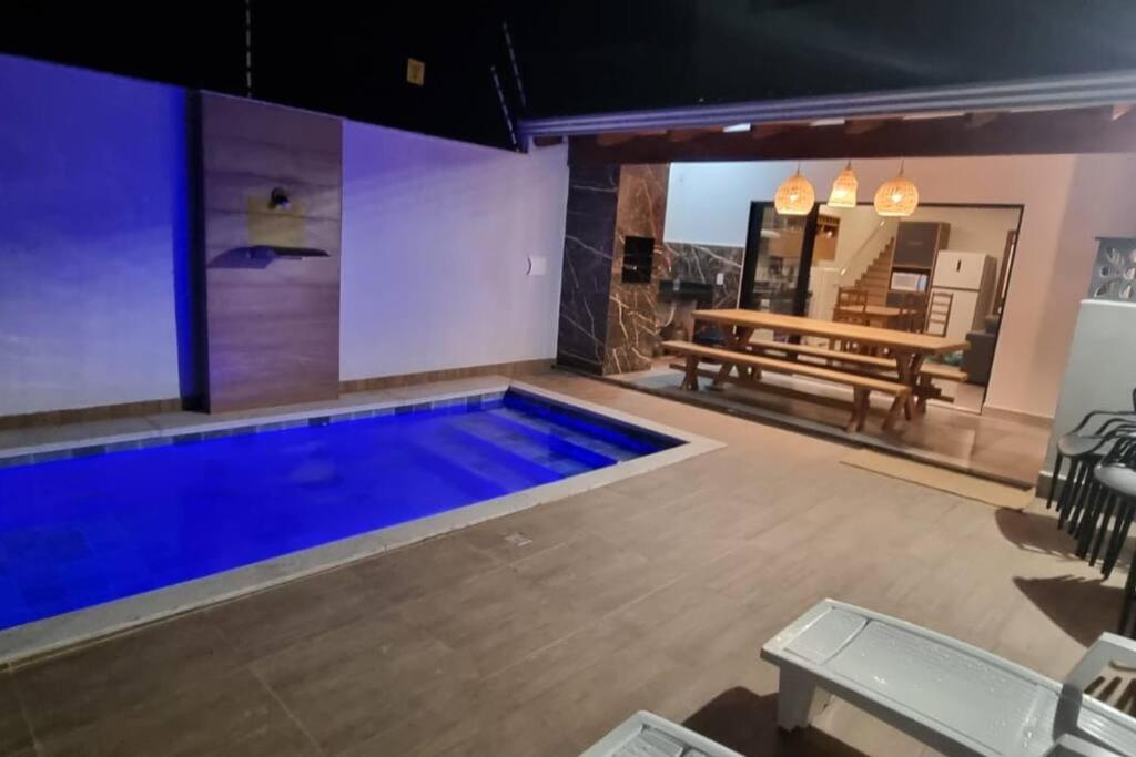 a swimming pool in a room with a table and a bench at Casa de férias Mirante Casa mar in Prado