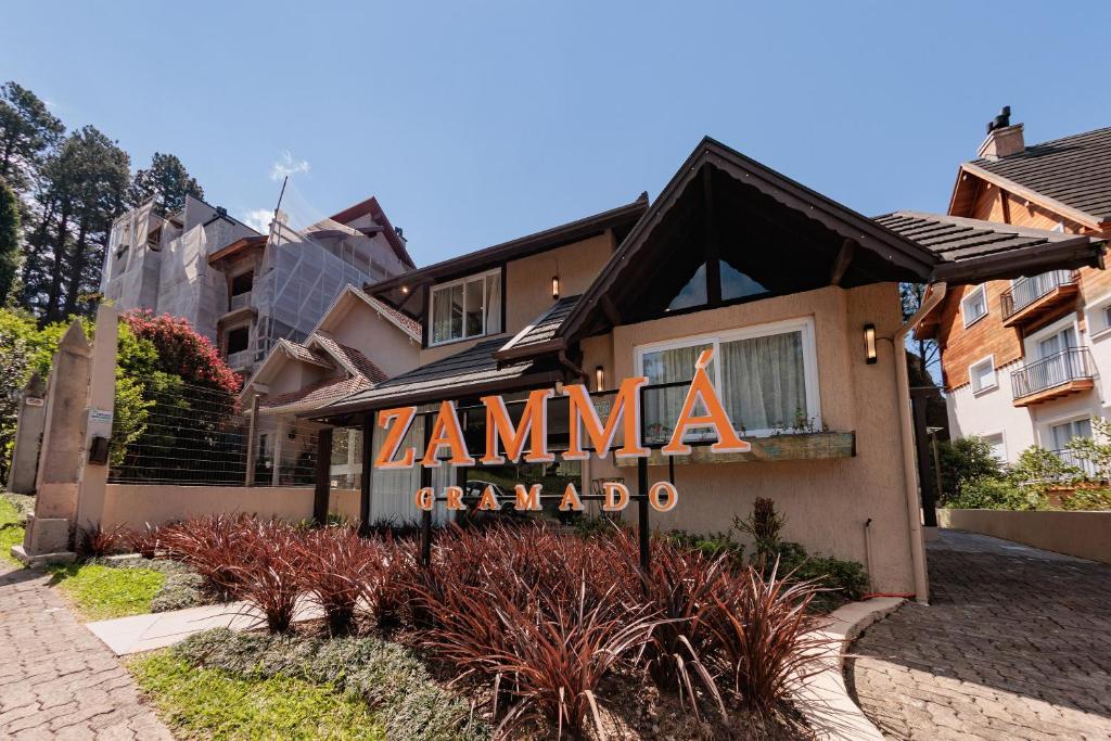 a house with a sign that reads zamma granada at Pousada Zammá Gramado in Gramado