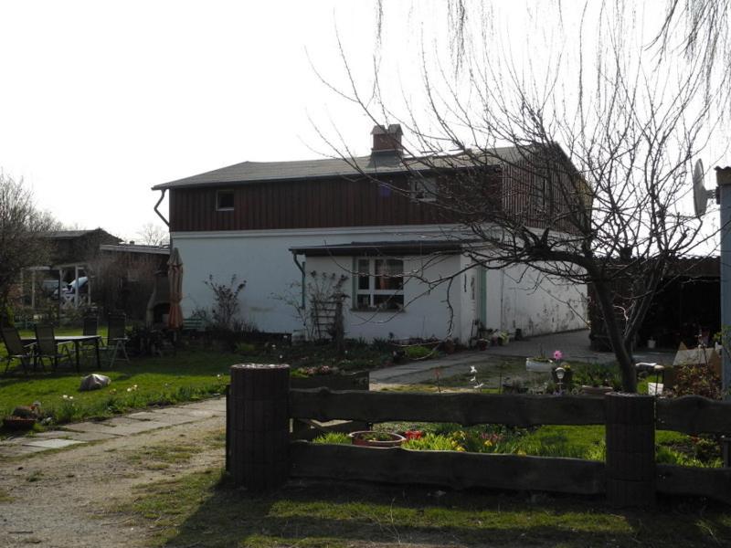 una casa con una valla delante de un patio en Ferienwohnung BoddenBlick, en Polchow