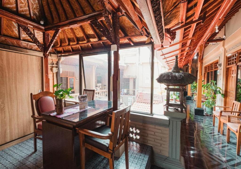 レギャンにあるTempo Doeloe Homestay Kutaのテーブルと椅子と窓のある部屋