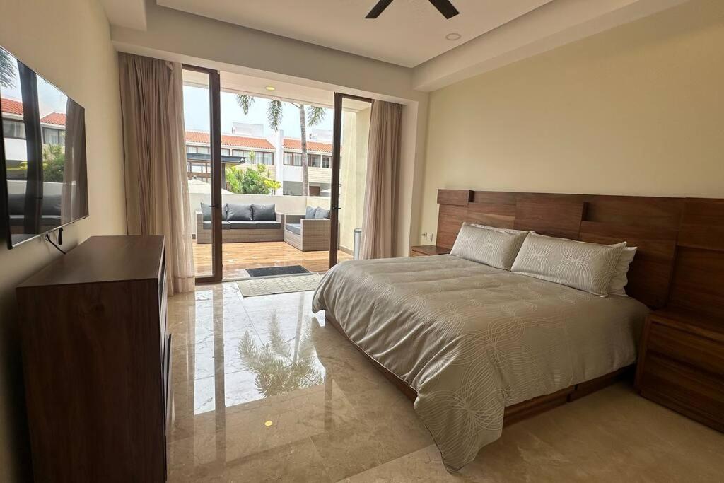 a bedroom with a large bed and a large window at Comfort at Club De Golf el Tigre in Nuevo Vallarta 