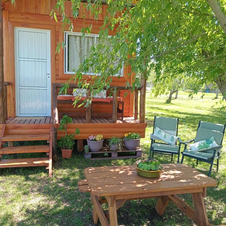 a wooden house with two chairs and a wooden table at Cabaña Don Juan in Villa Elisa