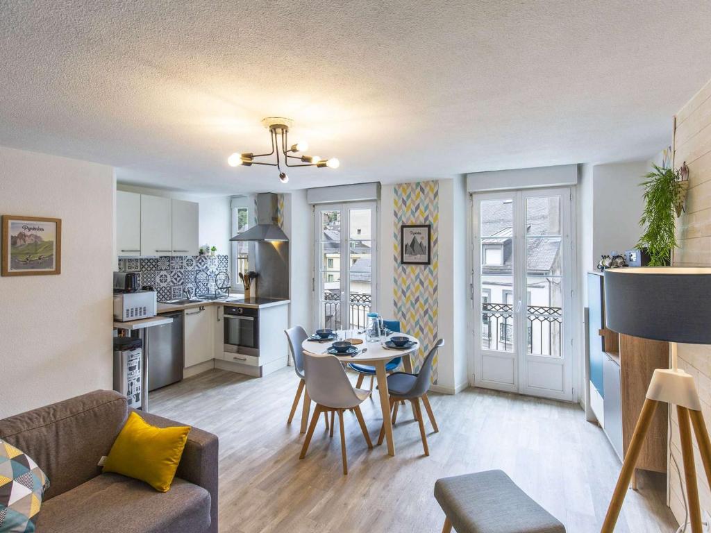 Il comprend un salon et une cuisine avec une table et des chaises. dans l'établissement Appartement Centre Cauterets, Confort Moderne, Cuisine Équipée - FR-1-401-307, à Cauterets