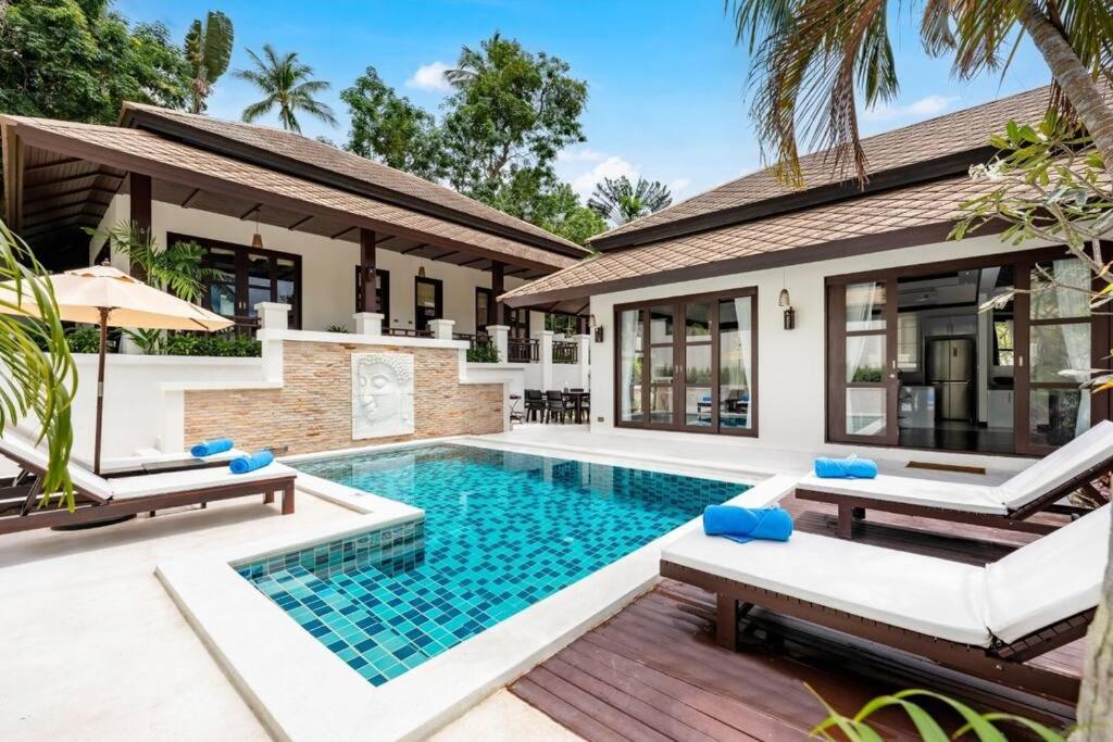 a villa with a swimming pool in front of a house at Renovated Luxury 3 Bed Pool Villa Kirikayan Maenam Koh Samui in Amphoe Koh Samui