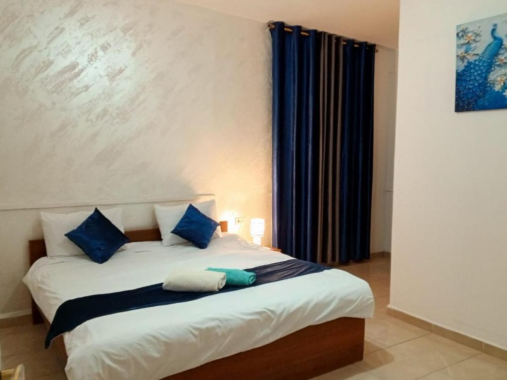 a bedroom with a bed with blue pillows at Jordan River hotel in Amman
