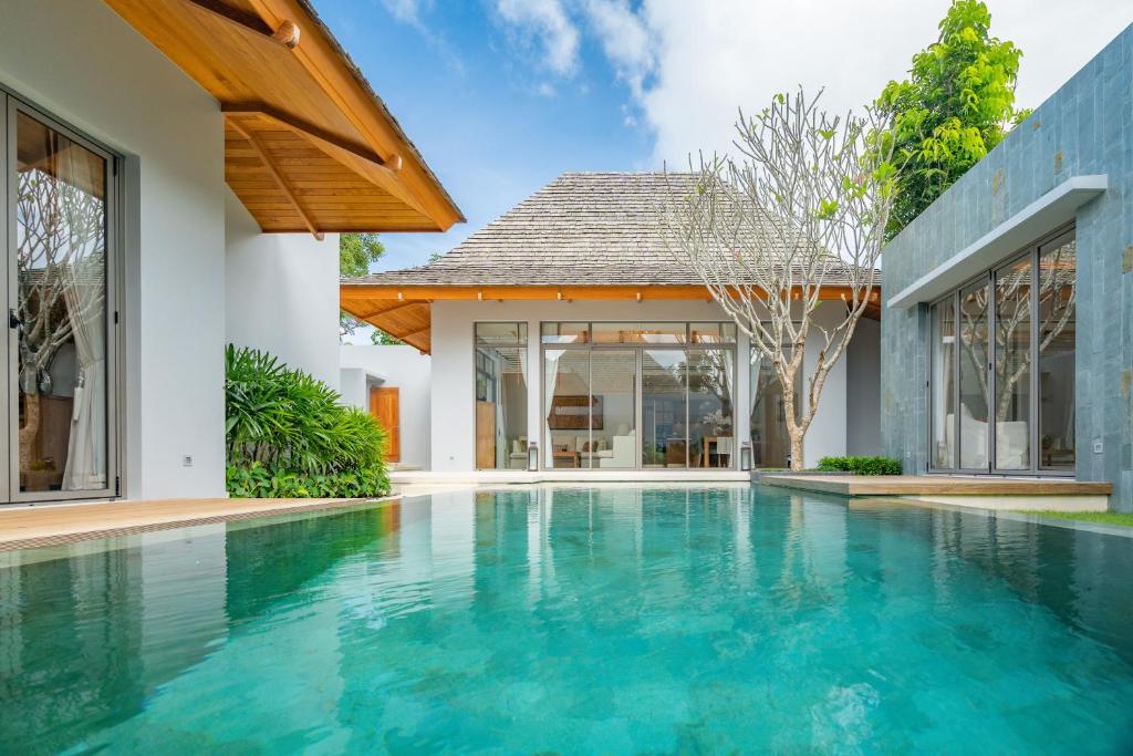 a swimming pool in the backyard of a villa at Modern 3BR Pool Villa at Anchan Flora in Bangtao in Bang Tao Beach
