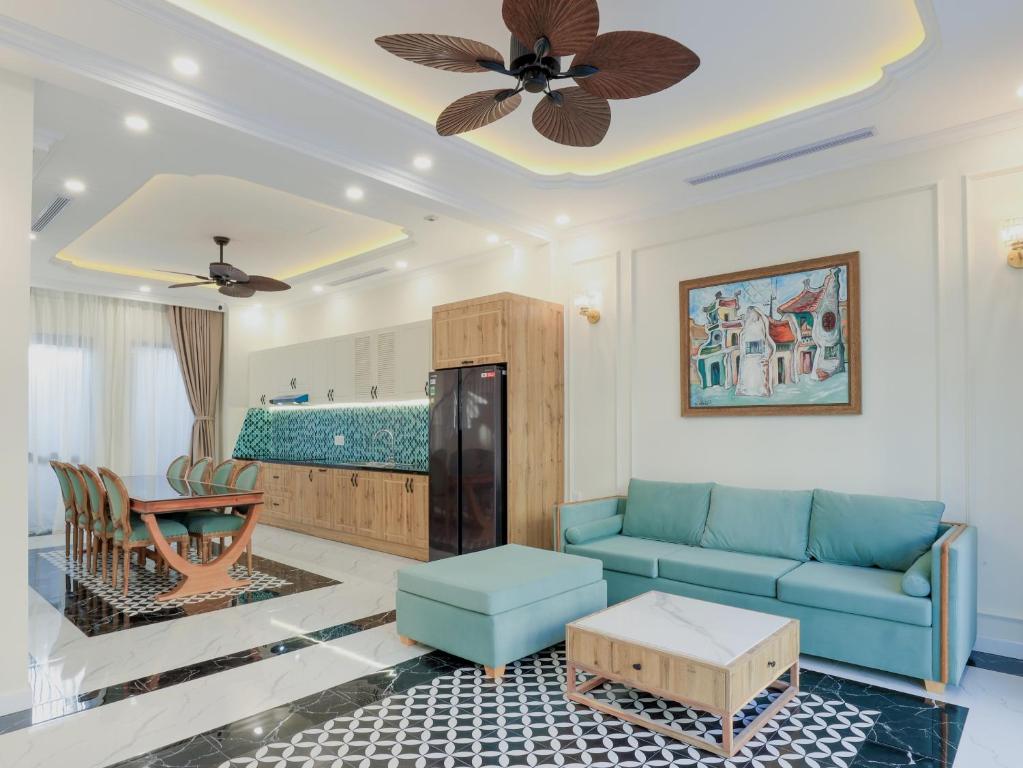 a living room with a blue couch and a table at Sea Casa Ho Tram - Villa nghỉ dưỡng sát biển Hồ Tràm in Xuyên Mộc